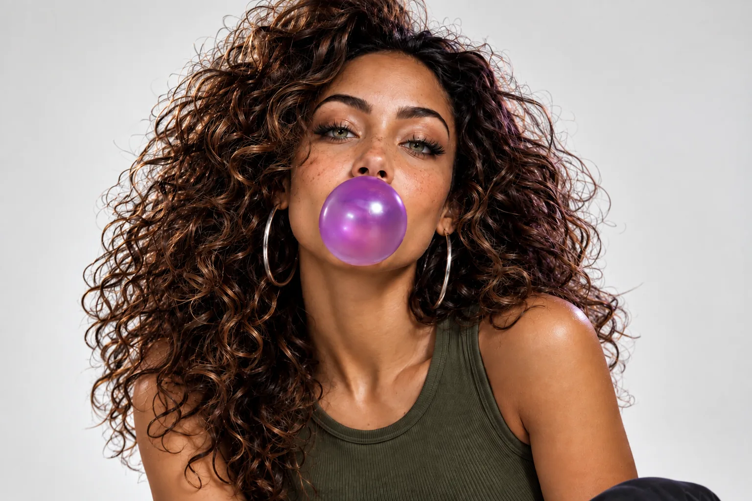 A studio portrait of a model blowing a bubblegum bubble
