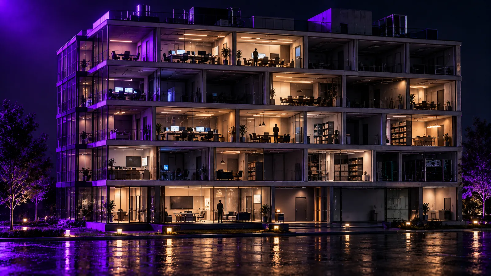 An office building at night with some rooms lit and occupied and others dark and empty